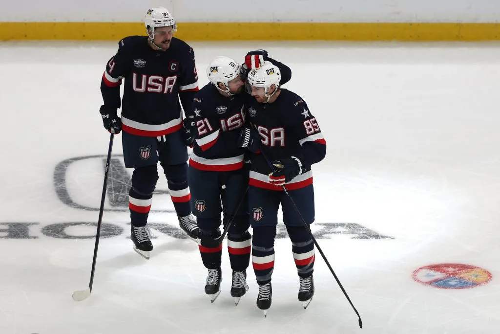 Jake Sanderson #85 of Team United States celebrates with Dylan Larkin #21 and Auston Matthews #34