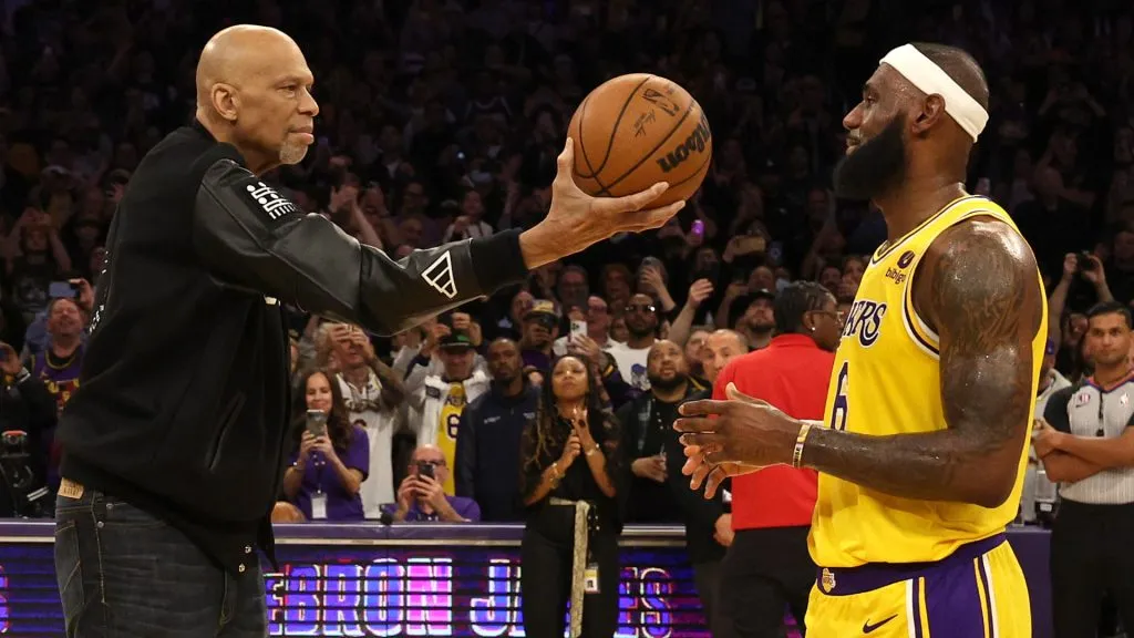Kareem Abdul-Jabbar ceremoniously hands LeBron James #6 of the Los Angeles Lakers the ball after James passed Abdul-Jabbar to become the NBA’s all-time leading scorer. (Harry How/Getty Images)
