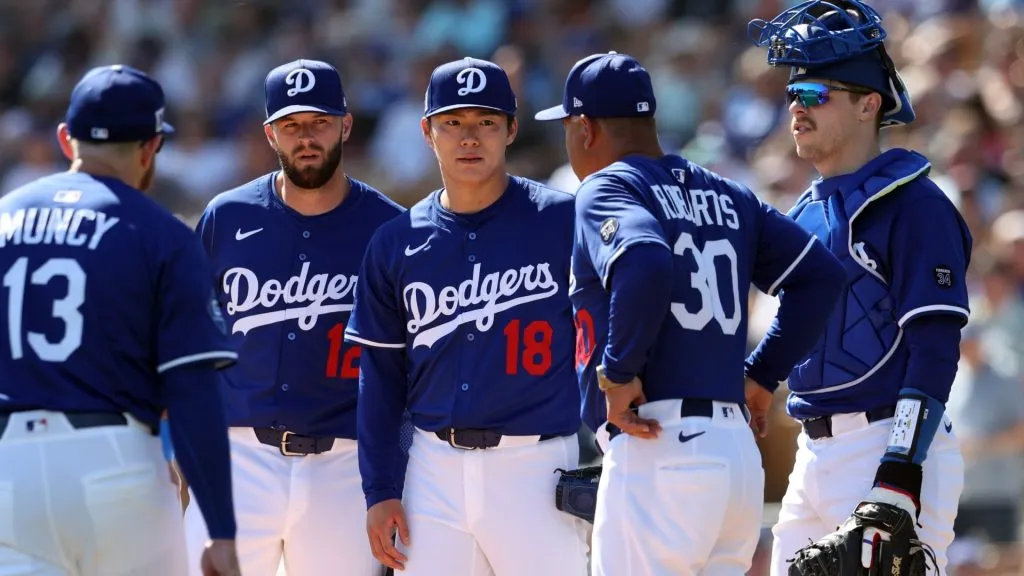 Manager Dave Roberts #30 of the Los Angeles Dodgers talks to Yoshinobu Yamamoto #18 before a pitching change during the first inning of a spring training game against the Chicago Cubs at Camelback Ranch on February 20, 2025 in Glendale, Arizona. (Photo by Chris Coduto/Getty Images)