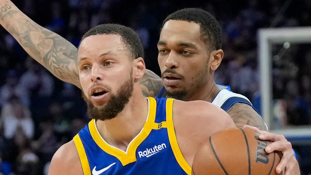 Stephen Curry #30 of the Golden State Warriors goes to the basket past P.J. Washington #25 of the Dallas Mavericks