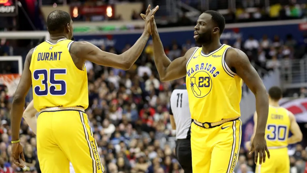Kevin Durant #35 and Draymond Green #23 of the Golden State Warriors celebrate in the second half against the Washington Wizards at Capital One Arena. (Rob Carr/Getty Images)