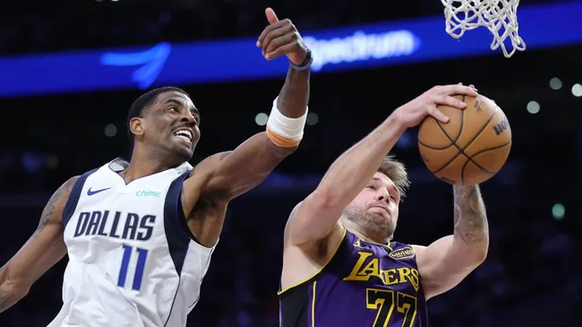 Luka Doncic #77 of the Los Angeles Lakers rebounds past Kyrie Irving #11 of the Dallas Mavericks during the first half of a game at Crypto.com Arena. (Sean M. Haffey/Getty Images)