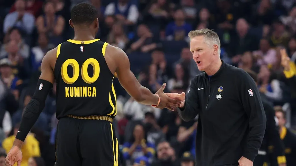 Golden State Warriors head coach Steve Kerr shakes hands with Jonathan Kuminga during a game against the Memphis Grizzlies on March 20, 2024.