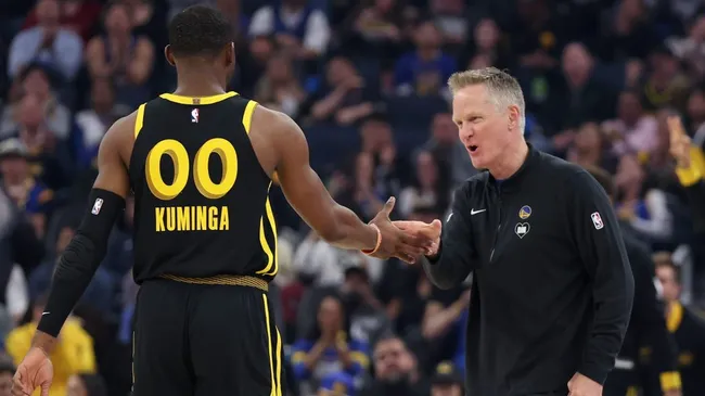 Steve Kerr shaking hand withthe young prospect Jonathan Kuminga
