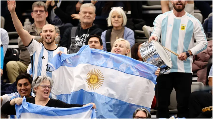 Fans of Argentina cheer whilst waving a flag