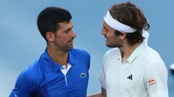 Novak Djokovic embraces Stefanos Tsitsipas on January 11, 2024 in Melbourne, Australia.