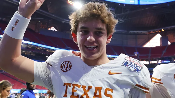 Arch Manning #16 and Cole Lourd #19 of the Texas Longhorns celebrate after defeating the Arizona State Sun Devils 39-31 during the second overtime in the Chick-fil-A Peach Bowl at Mercedes-Benz Stadium on January 01, 2025 in Atlanta, Georgia.