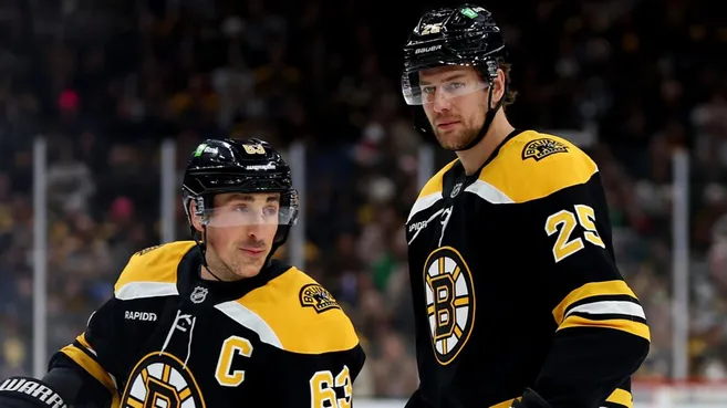 Brad Marchand #63 of the Boston Bruins and Brandon Carlo #25 look on during the first period against the Buffalo Sabres at TD Garden on December 21, 2024 in Boston, Massachusetts