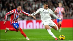 Kylian Mbappe of Real Madrid shoots under pressure from Jose Gimenez of Atletico de Madrid