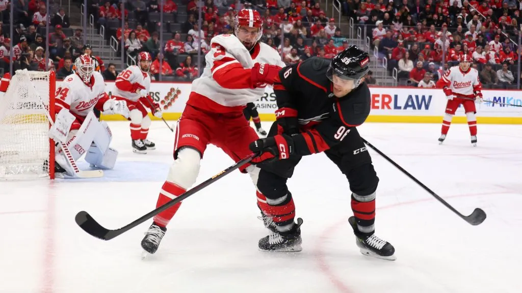 Mikko Rantanen #96 of the Carolina Hurricanes tries to control the puck in front of Justin Holl #3 of the Detroit Red Wings during the first period at Little Caesars Arena on March 04, 2025 in Detroit, Michigan. (Photo by Gregory Shamus/Getty Images)