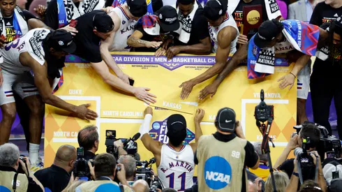 Kansas Jayhawks players place the team in the center of the bracket after defeating the North Carolina Tar Heels during the 2022 NCAA Men's Basketball Tournament National Championship.