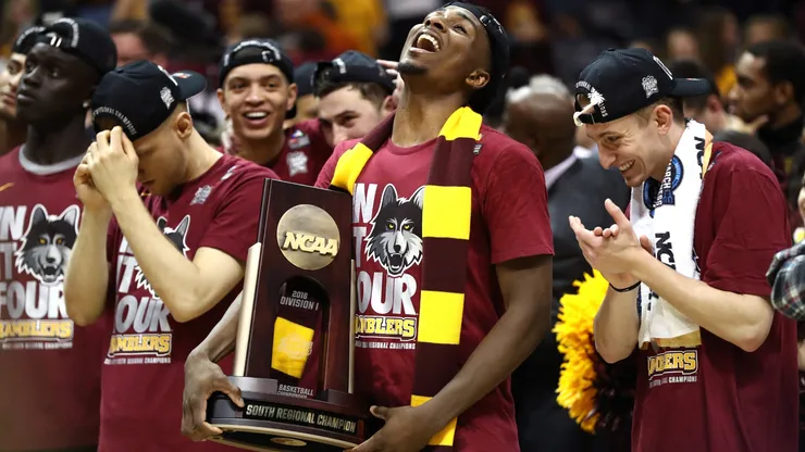 Donte Ingram #0 of the Loyola Ramblers celebrates with the trophy after defeating the Kansas State Wildcats during the 2018 NCAA Men's Basketball Tournament South Regional.