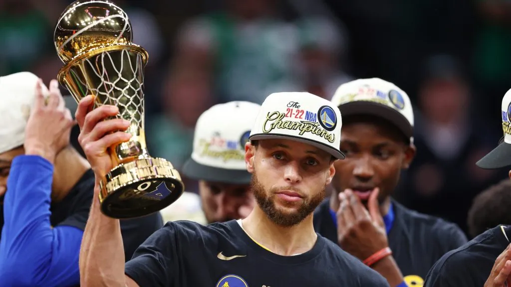 Stephen Curry #30 of the Golden State Warriors raises the Bill Russell NBA Finals Most Valuable Player Award after defeating the Boston Celtics. (Elsa/Getty Images)