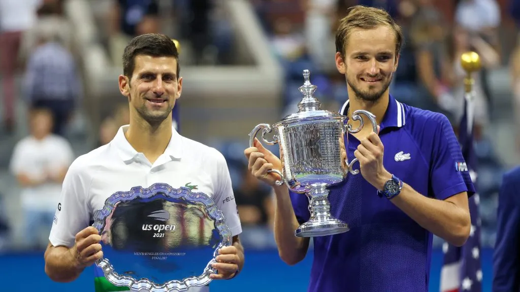 Novak Djokovic holds the runner-up trophy alongside Daniil Medvedev who celebrates with the championship trophy after winning their  final match of the 2021 US Open. (Matthew Stockman/Getty Images)
