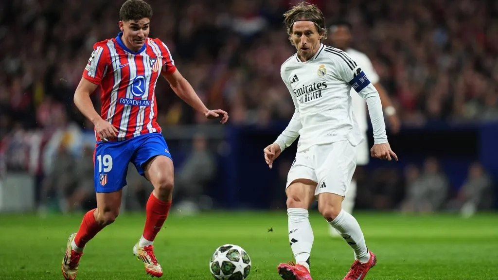 Luka Modric of Real Madrid passes the ball whilst under pressure from Julian Alvarez of Atletico Madrid.