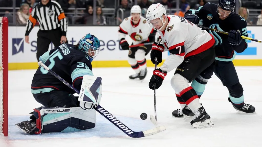 Joey Daccord #35 of the Seattle Kraken makes a save against Brady Tkachuk #7 of the Ottawa Senators during the first period at Climate Pledge Arena on January 04, 2024 in Seattle, Washington. (Photo by Steph Chambers/Getty Images)