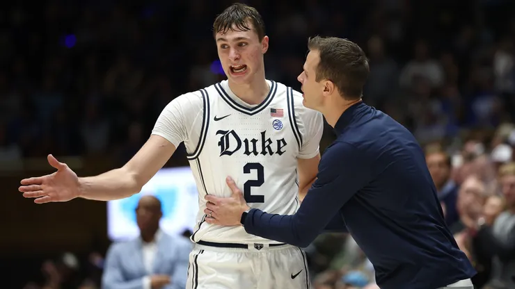 Head coach Jon Scheyer of the Duke Blue Devils speaks with Cooper Flagg.
