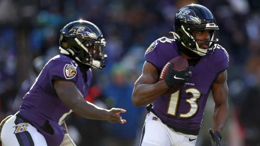 Wide receiver Devin Duvernay #13 of the Baltimore Ravens takes a handoff from quarterback quarterback Lamar Jackson #8 against the Carolina Panthers at M&amp;T Bank Stadium on November 20, 2022 in Baltimore, Maryland.