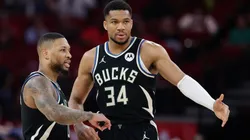 Damian Lillard #0 and Giannis Antetokounmpo #34 of the Milwaukee Bucks speak on the court during the first half against the Houston Rockets.