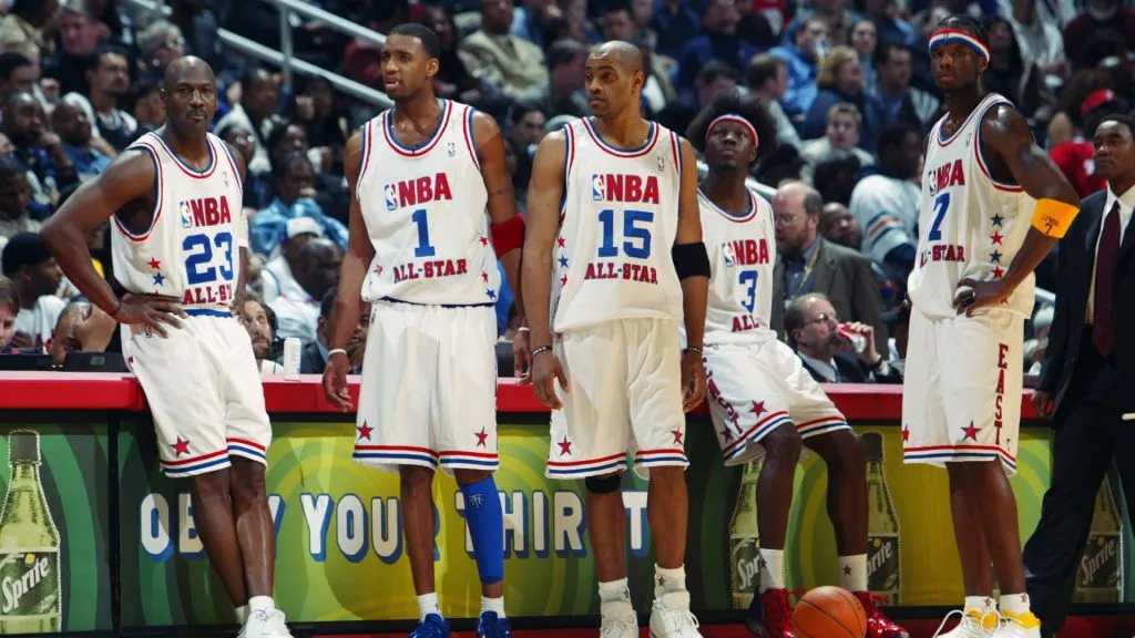 Michael Jordan stands next to Tracy McGrady at the 2003 NBA All-Star Game. Beside them are Vince Carter, Ben Wallace, and Jermaine O’Neal.