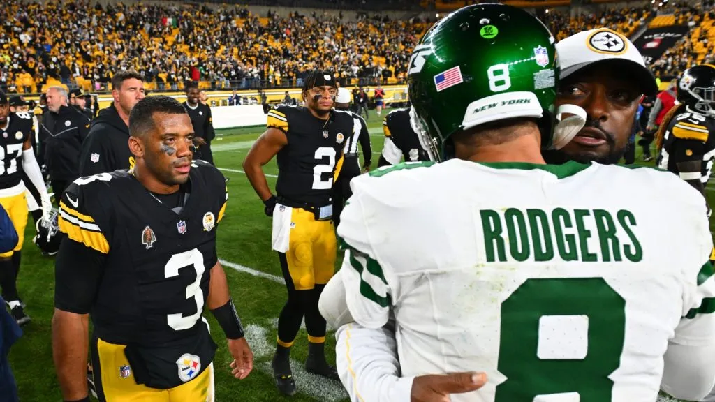 Russell Wilson #3 and Justin Fields #2 of the Pittsburgh Steelers look on as head coach Mike Tomlin of the Pittsburgh Steelers and Aaron Rodgers #8 of the New York Jets embrace after the game at Acrisure Stadium on October 20, 2024 in Pittsburgh, Pennsylvania.