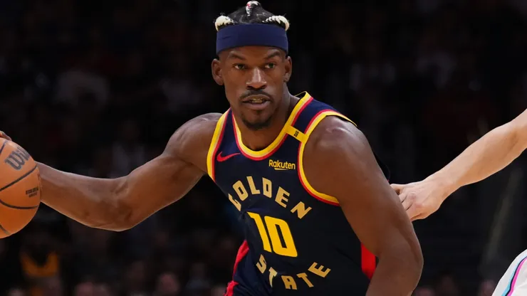 Jimmy Butler III #10 of the Golden State Warriors dribbles the ball against Tyler Herro #14 of the Miami Heat during the first quarter at Kaseya Center on March 25, 2025 in Miami, Florida.