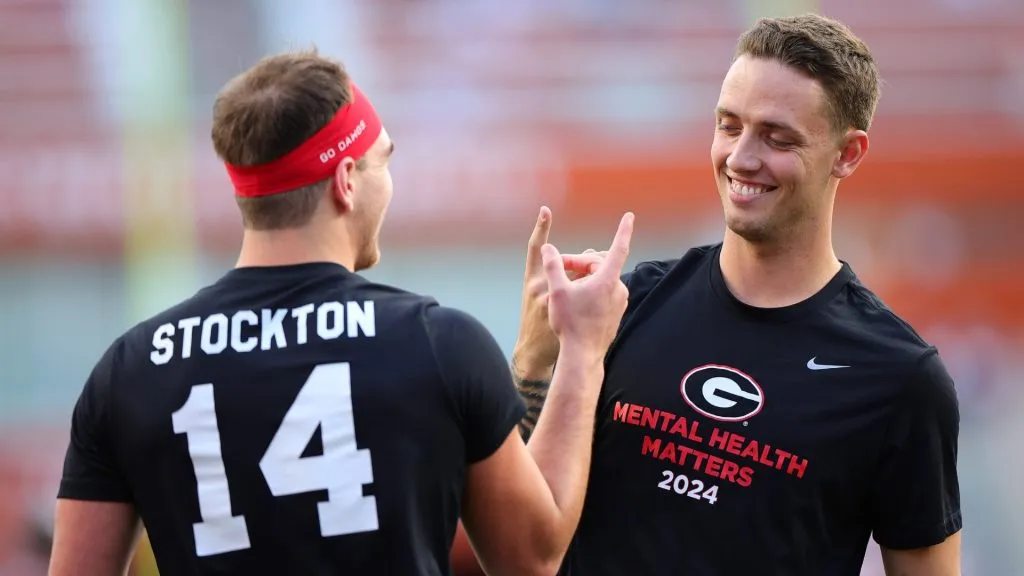 Gunner Stockton #14 and Carson Beck #15 of the Georgia Bulldogs react prior to a game against the Texas Longhorns at Darrell K Royal-Texas Memorial Stadium on October 19, 2024 in Austin, Texas.