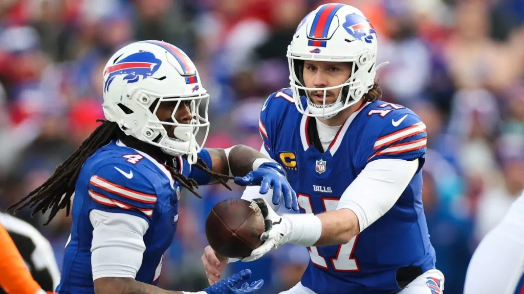 Josh Allen #17 of the Buffalo Bills hands off the ball to teammate James Cook #4 in the third quarter against the Denver Broncos during the AFC Wild Card Playoffs at Highmark Stadium on January 12, 2025 in Orchard Park, New York.