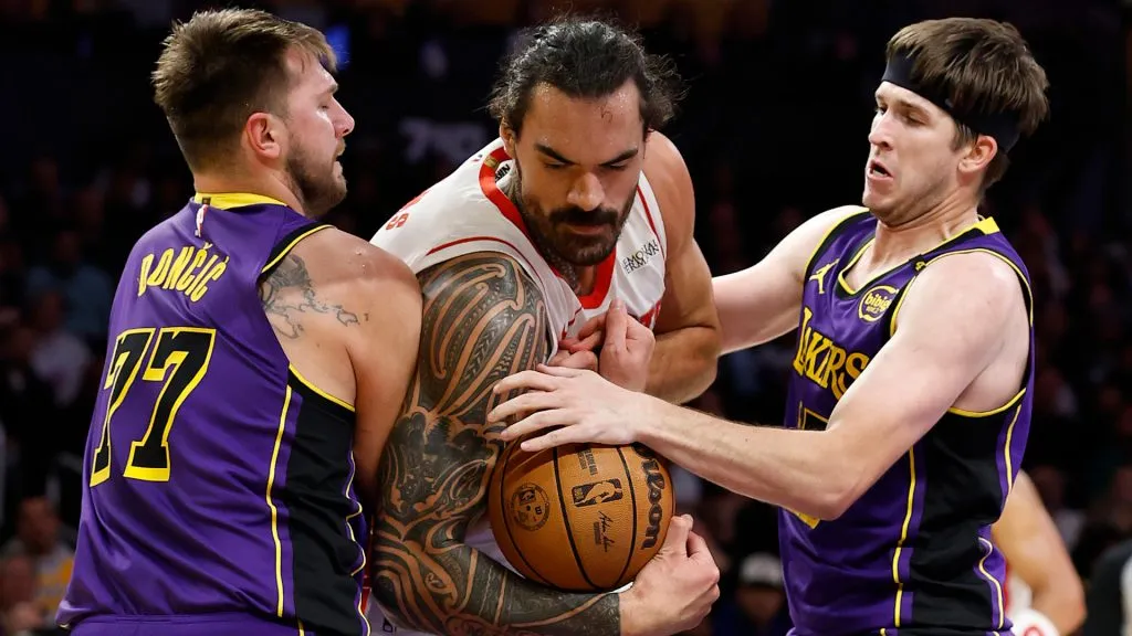 Steven Adams #12 of the Houston Rockets controls the ball against Austin Reaves #15 and Luka Doncic #77 of the Los Angeles Lakers. (Ronald Martinez/Getty Images)