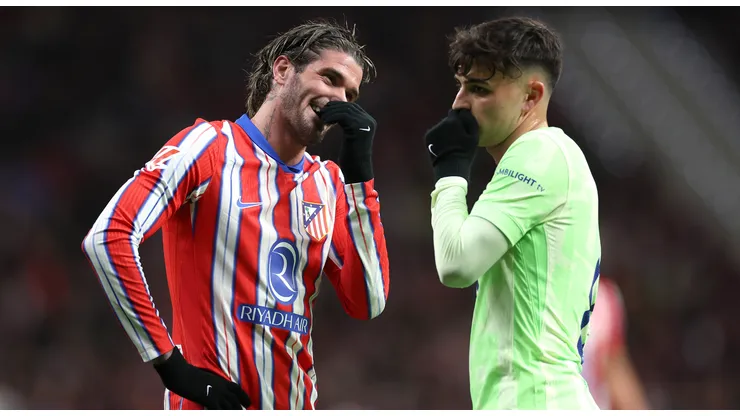 Rodrigo De Paul of Atletico de Madrid (L) speaks with Pedri of FC Barcelona during the La Liga EA Sports match between Atletico de Madrid and FC Barcelona at Riyadh Air Metropolitano on March 16, 2025 in Madrid, Spain.