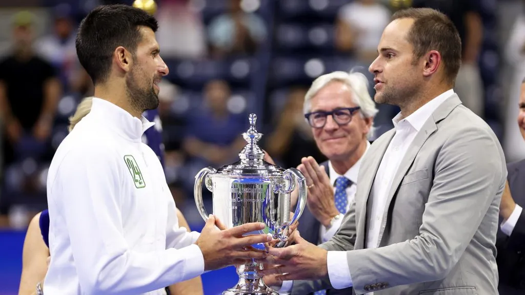 Novak Djokovic of Serbia receives his winners trophy from Andy Roddick after defeating Daniil Medvedev in the 2023 US Open final. (Clive Brunskill/Getty Images)