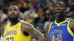 LeBron James #23 of the Los Angeles Lakers and Draymond Green #23 of the Golden State Warriors watch as a Warriors player shoots a free throw.