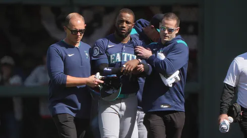 Victor Robles #10 of the Seattle Mariners is helped off the field after hurting himself while catching a foul fly ball and running into the wall flipping over the fence into the netting against the San Francisco Giants in the bottom of the ninth inning at Oracle Park on April 06, 2025 in San Francisco, California.