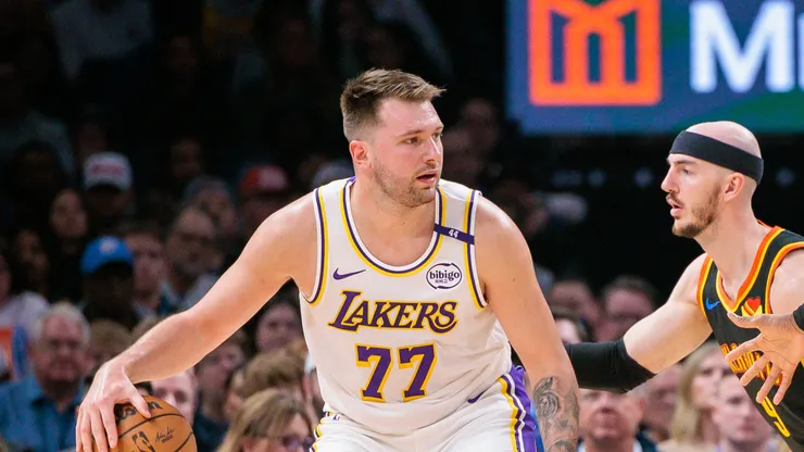 Luka Doncic #77 of the Los Angeles Lakers drives to the basket around Shai Gilgeous-Alexander #2 of the Oklahoma City Thunder and Alex Caruso #9 of the Oklahoma City Thunder