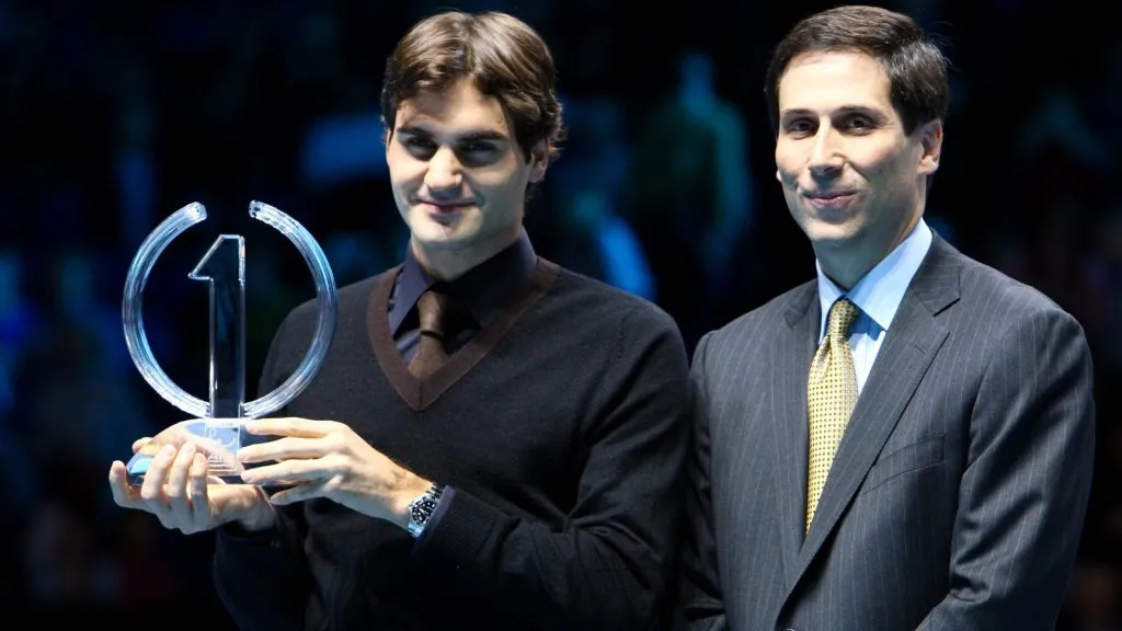 Federer of Switzerland poses with the ATP World Tour Champion Trophy next to The ATP Executive Charmiman and President Adam Helfant during the Barclays ATP World Tour Finals in 2009. (Source: Julian Finney/Getty Images)