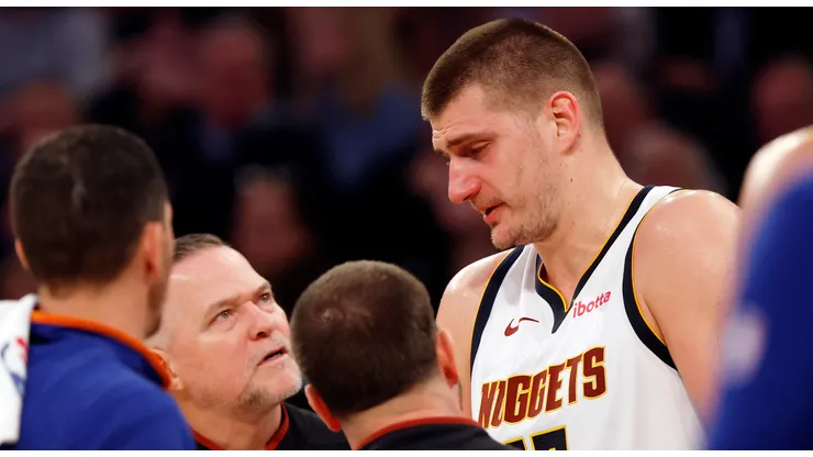 Nikola Jokic #15 reacts with head coach Michael Malone of the Denver Nuggets after an injury to his eye during the first half against the New York Knicks at Madison Square Garden on January 25, 2024 in New York City.