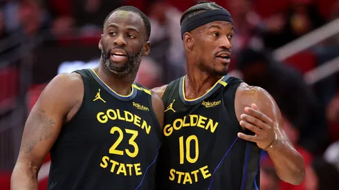 Draymond Green #23 and Jimmy Butler #10 of the Golden State Warriors speak on the court against the Houston Rockets during the first half at Toyota Center on February 13, 2025 in Houston, Texas.