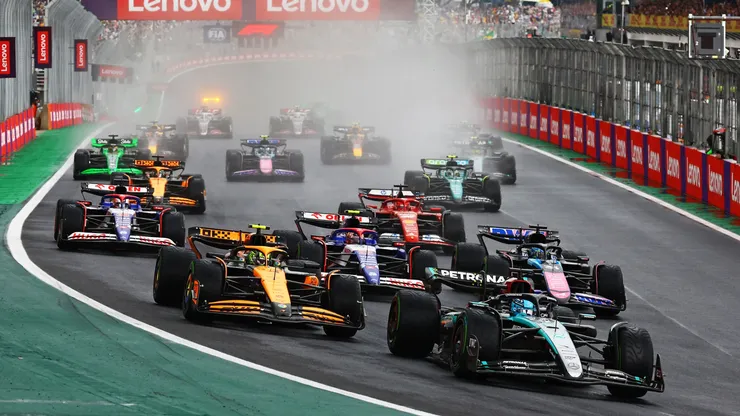 George Russell driving the (63) Mercedes AMG Petronas F1 Team W15 leads Lando Norris driving the (4) McLaren MCL38 Mercedes and the rest of the field into turn 1 during the F1 Grand Prix of Brazil in 2024.