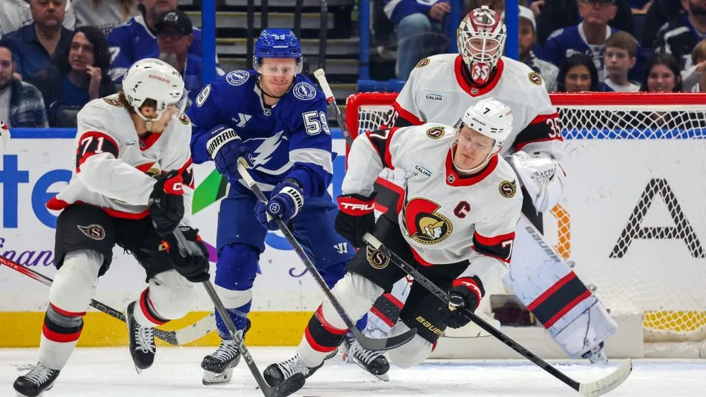 Ridly Greig #71 of the Ottawa Senators clears the puck as Jake Guentzel #59 of the Tampa Bay Lightning reaches out past Brady Tkachuk #7 in front of Linus Ullmark #35 during the first period at the Amalie Arena on February 4, 2025 in Tampa, Florida. (Photo by Mike Carlson/Getty Images)