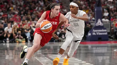 Caitlin Clark #22 of the Indiana Fever dribbles the ball while being guarded by Sydney Colson #51 of the Las Vegas Aces in the first quarter at Gainbridge Fieldhouse on September 11, 2024.