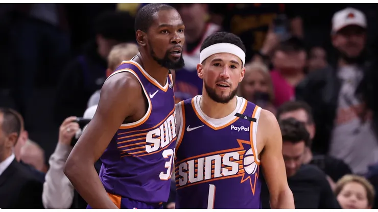 Kevin Durant #35 of the Phoenix Suns hugs Devin Booker #1 after the Suns defeated the Golden State Warriors 113-105 at Footprint Center on November 30, 2024 in Phoenix, Arizona.