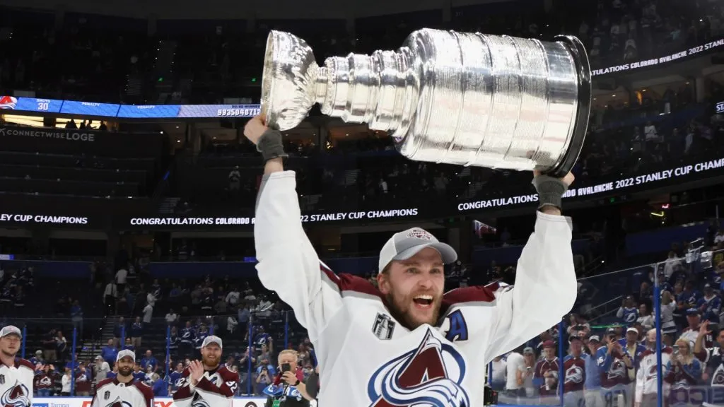 Mikko Rantanen #96 of the Colorado Avalanche carries the Stanley Cup following the series winning victory over the Tampa Bay Lightning in Game Six of the 2022 NHL Stanley Cup Final at Amalie Arena on June 26, 2022 in Tampa, Florida.