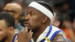 Jimmy Butler III #10 and Stephen Curry #30 of the Golden State Warriors watch from the bench during the second half of the NBA game against the Phoenix Suns at PHX Arena on April 08, 2025 in Phoenix, Arizona.