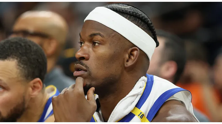 Jimmy Butler III #10 and Stephen Curry #30 of the Golden State Warriors watch from the bench during the second half of the NBA game against the Phoenix Suns at PHX Arena on April 08, 2025 in Phoenix, Arizona.