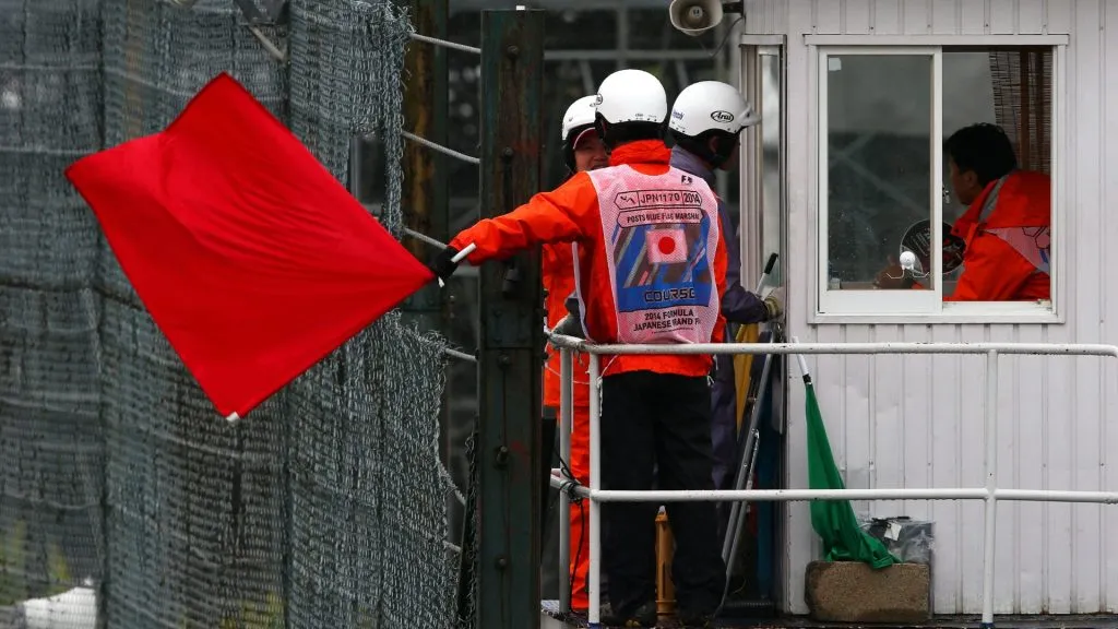A course marshall waves a red flag during the Japanese Formula One Grand Prix at Suzuka Circuit on October 5, 2014. (Source: Justin Davies/Getty Images)