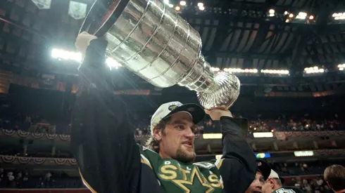 Captain Derian Hatcher of the Dallas Stars carries the Stanley Cup after the Stanley Cup Final game against the Buffalo Sabres in 1999.