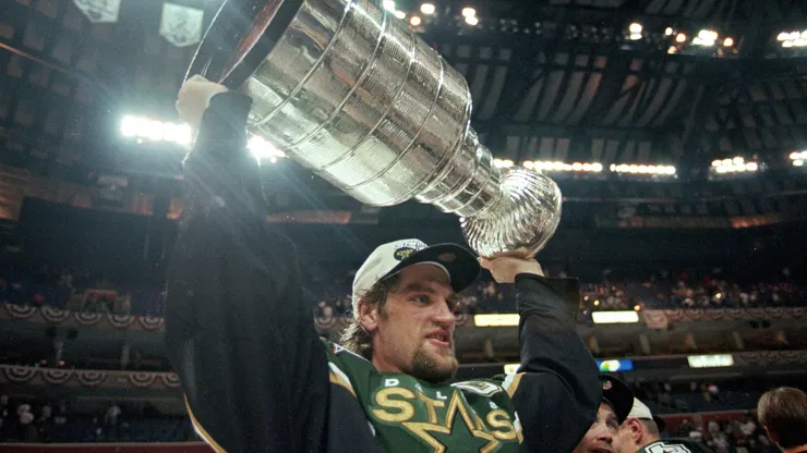Captain Derian Hatcher of the Dallas Stars carries the Stanley Cup after the Stanley Cup Final game against the Buffalo Sabres in 1999.