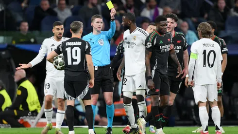 Referee Francois Letexier shows a yellow card to Thomas Partey during the UEFA Champions League match between Real Madrid C.F. and Arsenal FC.