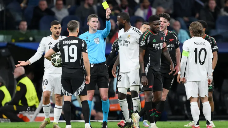 Referee Francois Letexier shows a yellow card to Thomas Partey during the UEFA Champions League match between Real Madrid C.F. and Arsenal FC.