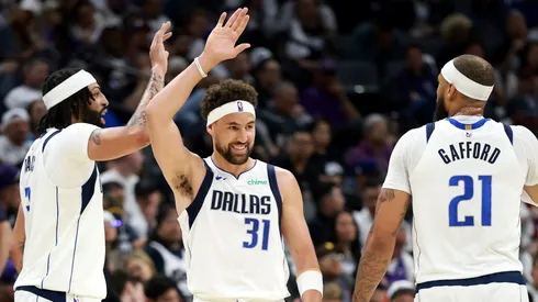 Klay Thompson #31 high fives Anthony Davis #3 and Daniel Gafford #21 of the Dallas Mavericks after Davis made a basket against the Sacramento Kings.